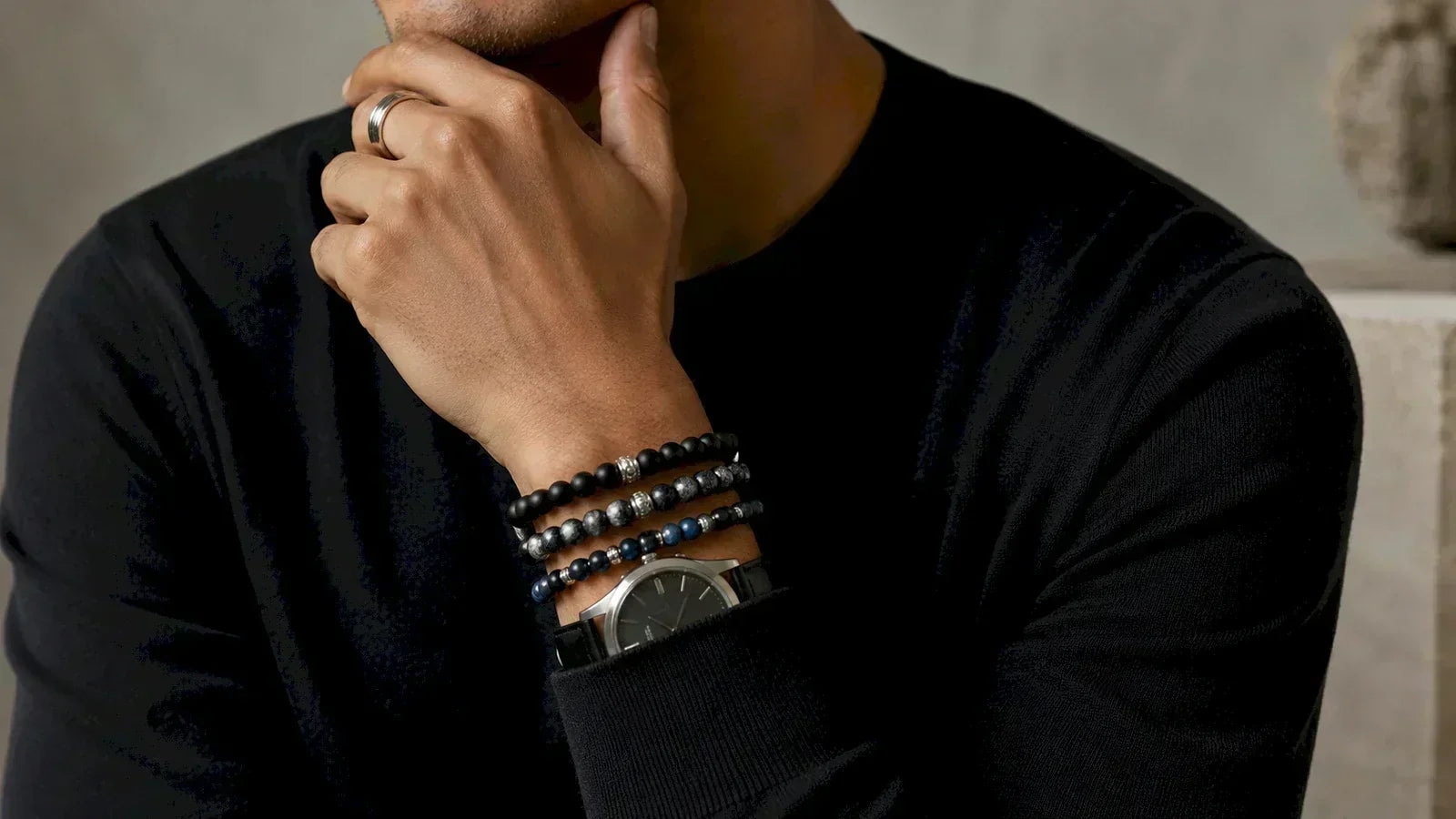Man styling a minimalist beaded bracelet with a neutral outfit and watch