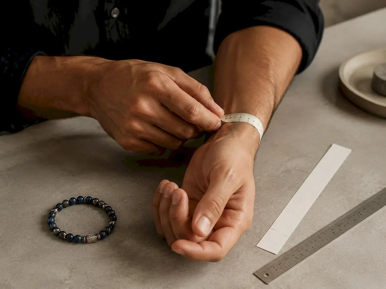 Man measuring his wrist with a soft tape for the ASIA'NOBLE men's bracelet size guide