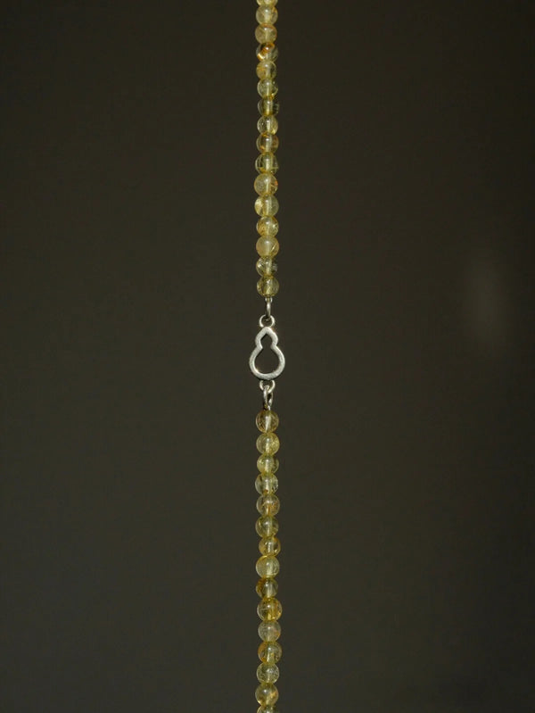 Editorial still life of Urban Dreamer bracelet, golden quartz and silver gourd design shown in refined artistic composition