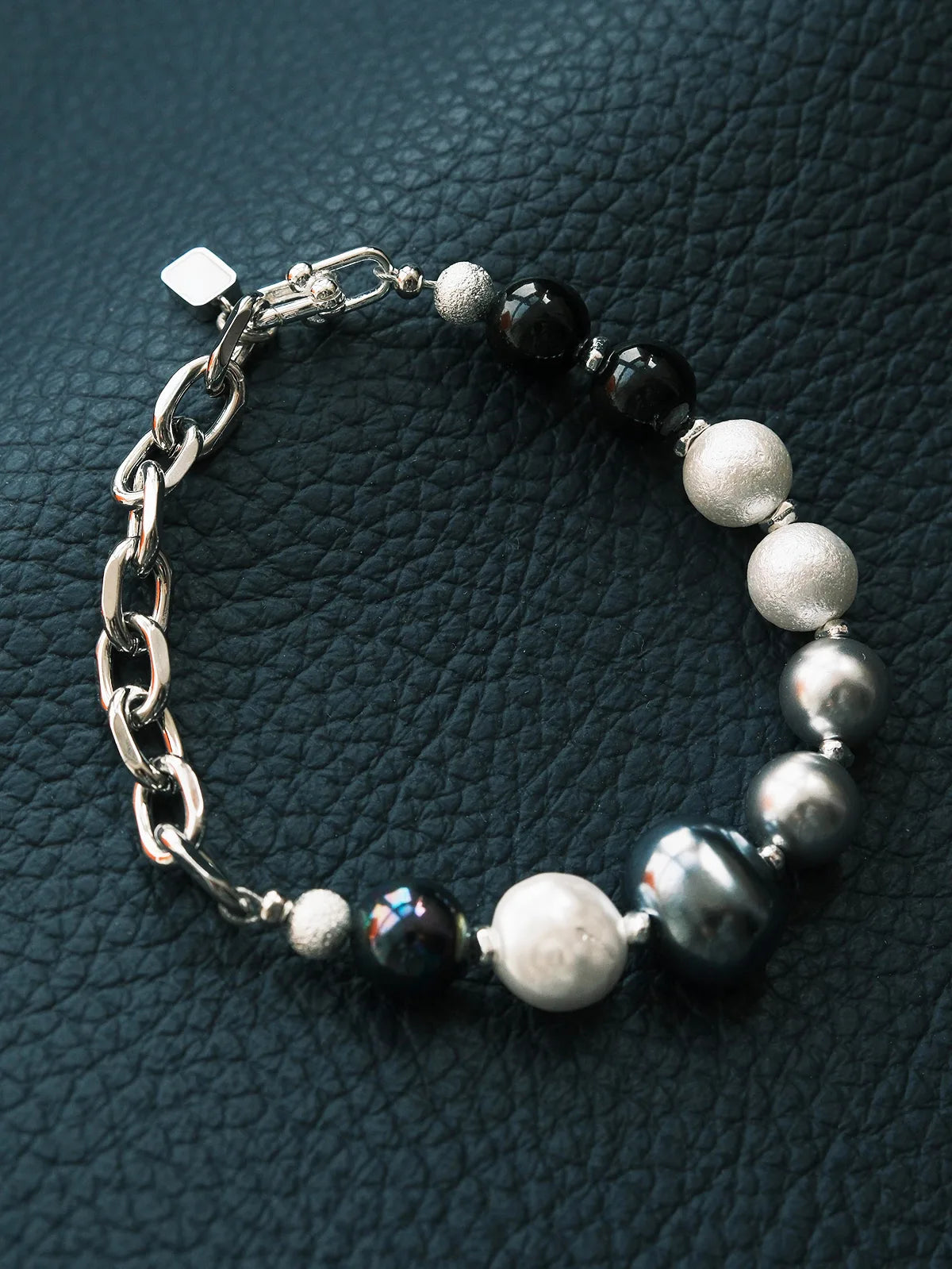 Black and white mood image of Bold Elegance men’s pearl bracelet with a cold minimalist masculine aesthetic