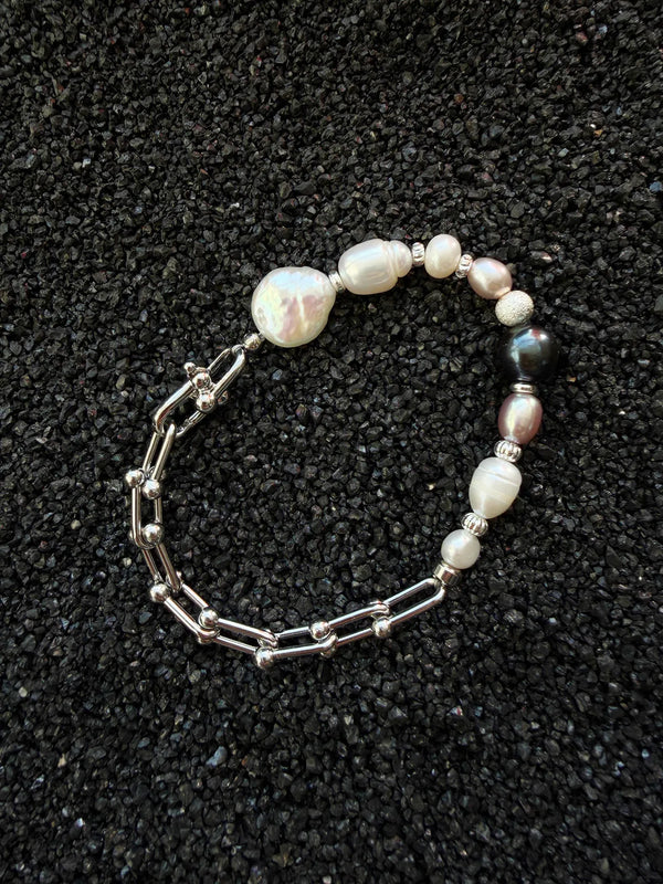 Editorial still life of a pearl bracelet for men, highlighting natural pearl texture and metal contrast