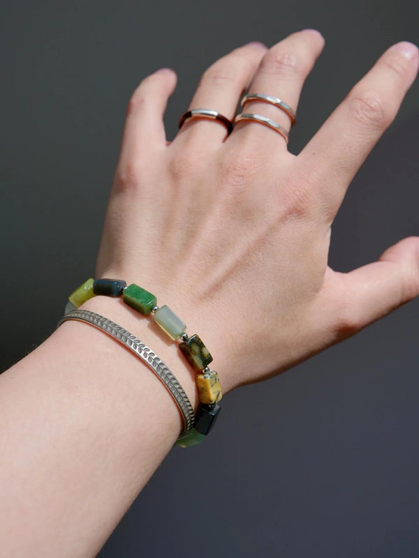 Men’s natural Xiuyu jade bracelet worn on wrist with minimalist silver accessories