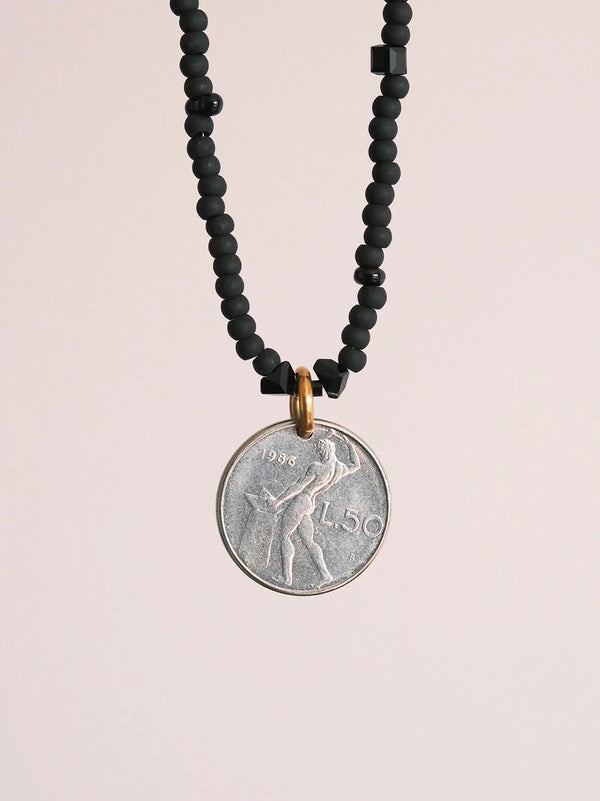 Black and white masculine mood image with men’s coin necklace inspired by strength, discipline, and control