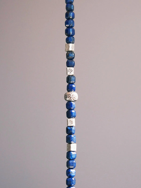 Vertical close-up of lapis lazuli beads men’s bracelet with sterling silver accents and natural stone texture