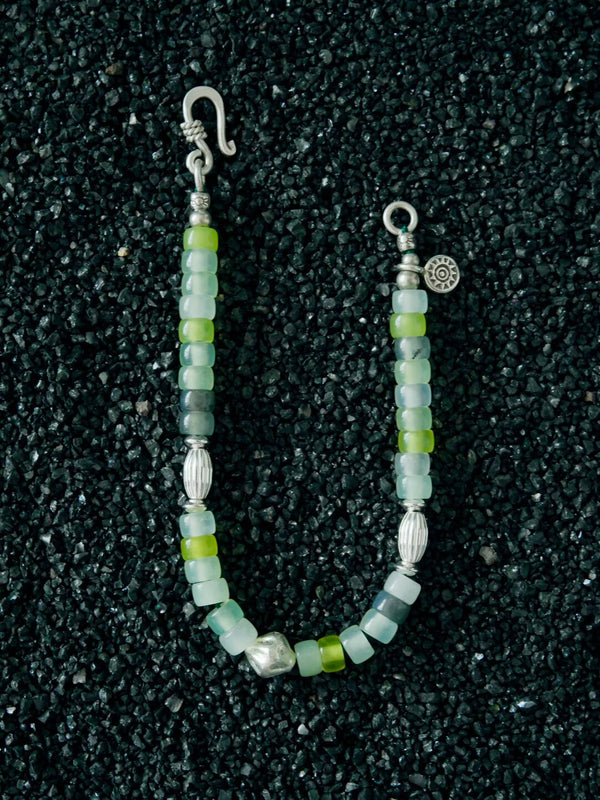Detail shot of serpentine jade beads, sterling silver spacers, and hook clasp on a handcrafted men’s bracelet