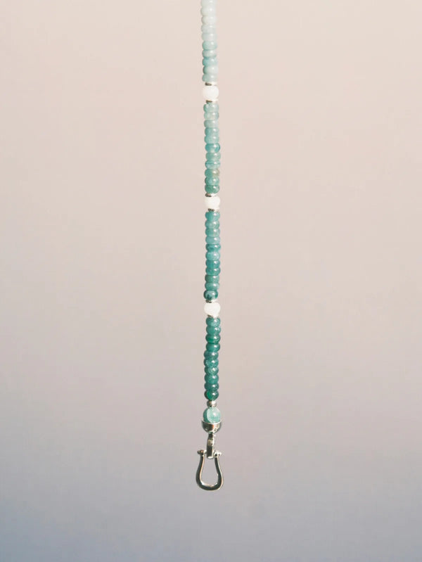 Ocean Bone blue jade bracelet suspended on a soft neutral background, highlighting its gradient jade color and titanium steel clasp