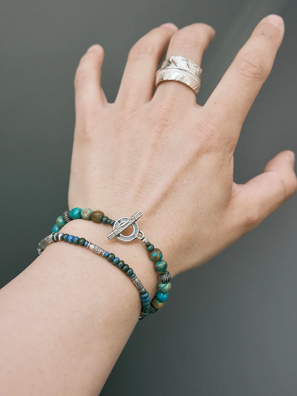 Layered men’s bracelet stack with turquoise beads, sterling silver accents, and minimalist daily wear style