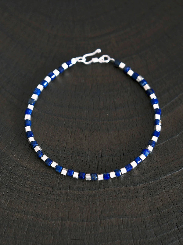 Moody men’s bracelet photography, blue lapis lazuli and sterling silver bracelet, cool-toned identity jewelry aesthetic.