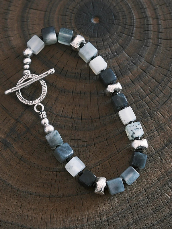 Close-up of natural jade, silver details, and Miyuki colored-glaze beads on a structured men’s beaded bracelet.