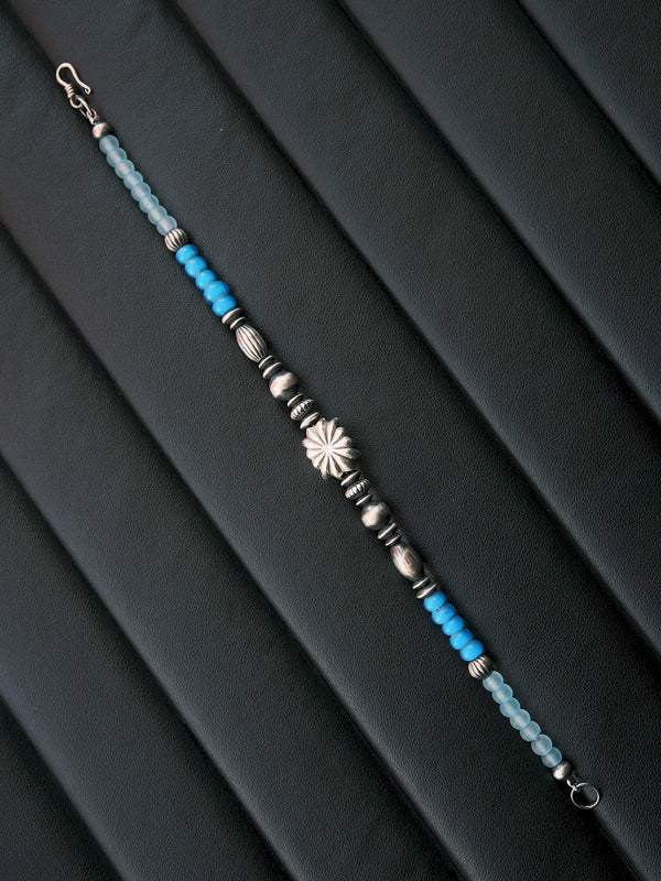 Black and white mood image of a men’s silver bracelet, showing quiet confidence, stoic energy, and refined masculine jewelry style.