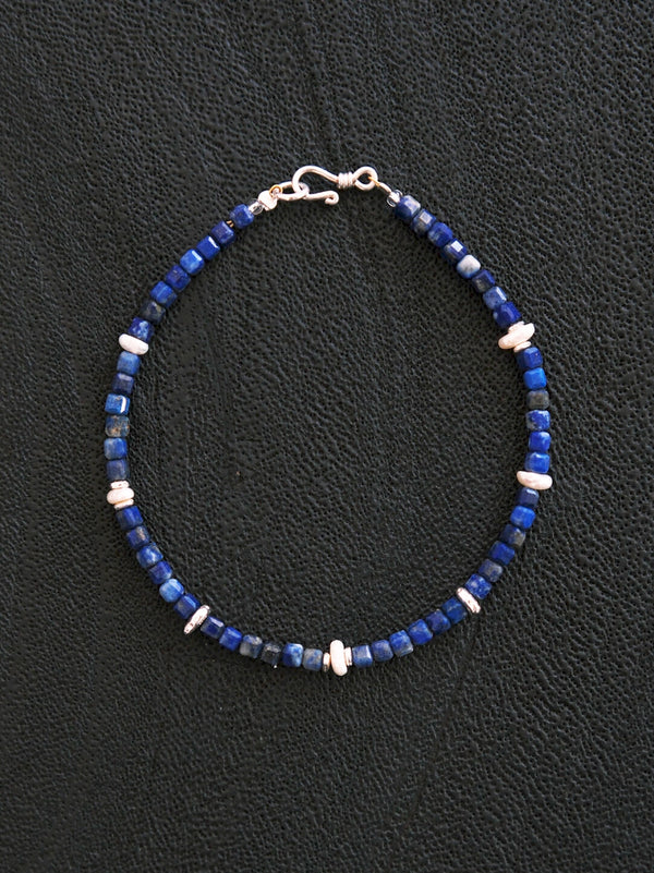 Close-up detail of lapis lazuli beads, pearl accents, and silver elements on a minimal men’s bracelet from Identity Series Blue Instinct.