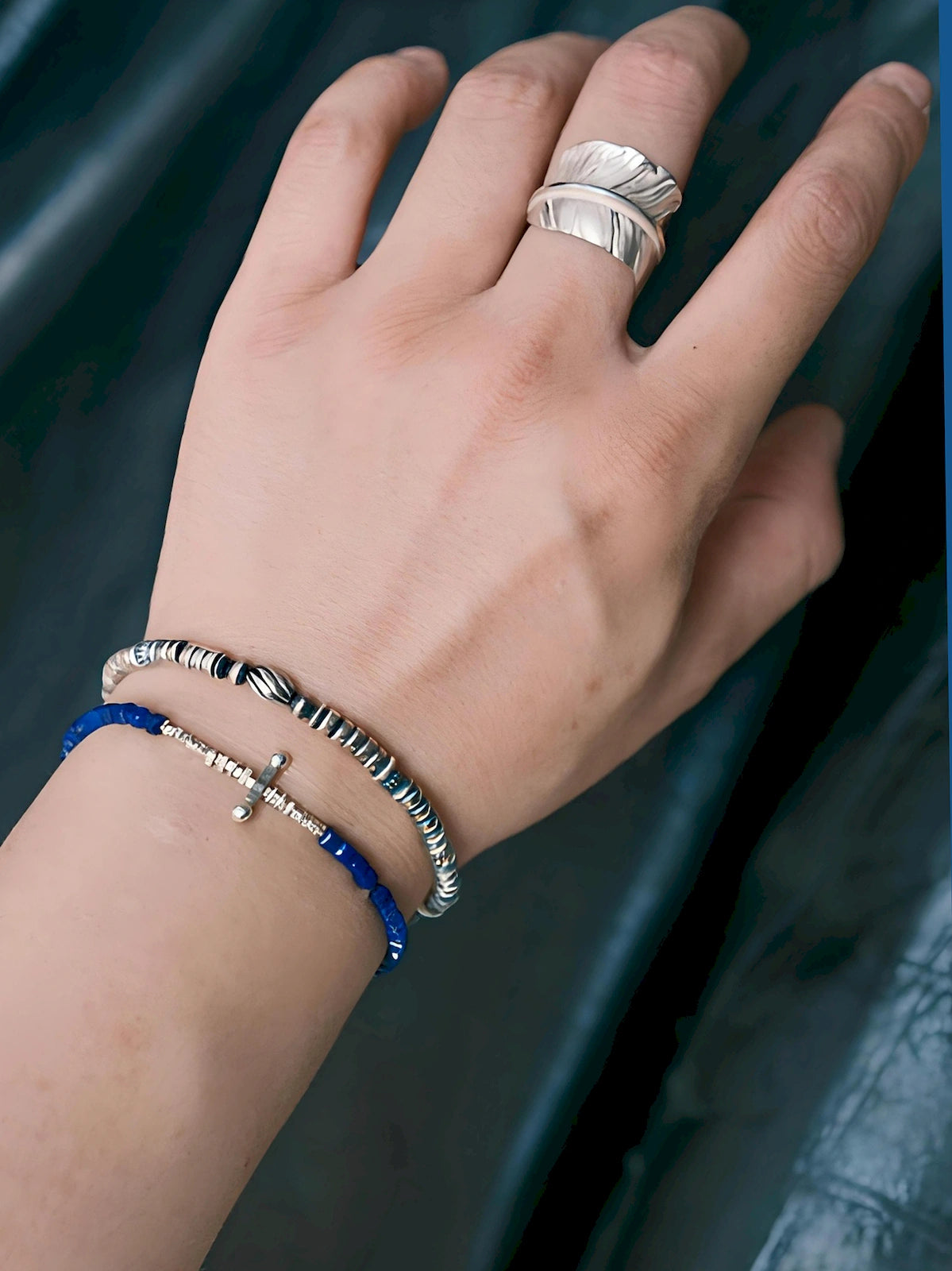 Silver Nomad silver bracelet and blue stone bracelet worn on hand, minimalist men's wrist stack