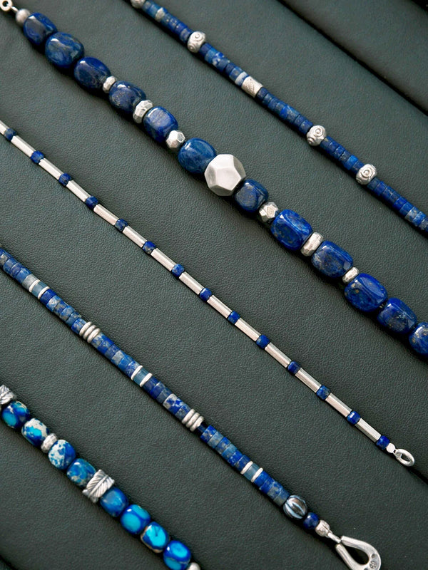 Black and white mood image of a men’s beaded bracelet, refined silver details, and calm masculine identity styling.