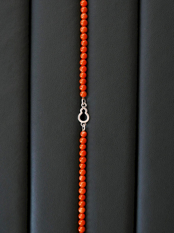 Close-up of full-color Nanhong agate beads and sterling silver FuLu gourd charm, polished red stone bracelet for men.