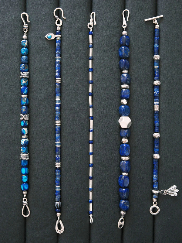 Men’s lapis lazuli bracelet styled on a work desk, featuring sterling silver feather details for a minimal office jewelry aesthetic.
