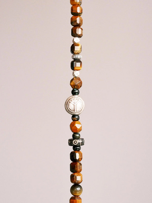 Close-up of tiger eye beads, horn beads, Thai silver details, and colored-glaze accents on a men’s Urban Stoic bracelet.