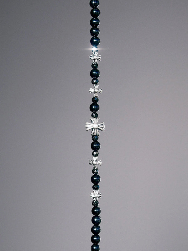 Close-up dark minimal men’s bracelet with black onyx beads, black spinel sparkle, and sterling silver cross-heart accents