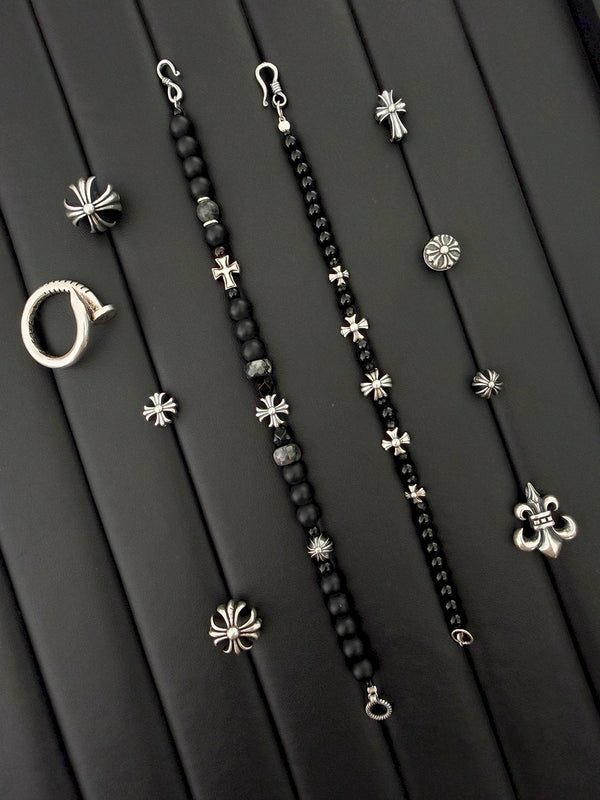 Close-up of black onyx beads, black spinel accents, Miyuki colored-glaze, and sterling silver cross-heart details on a men’s bracelet