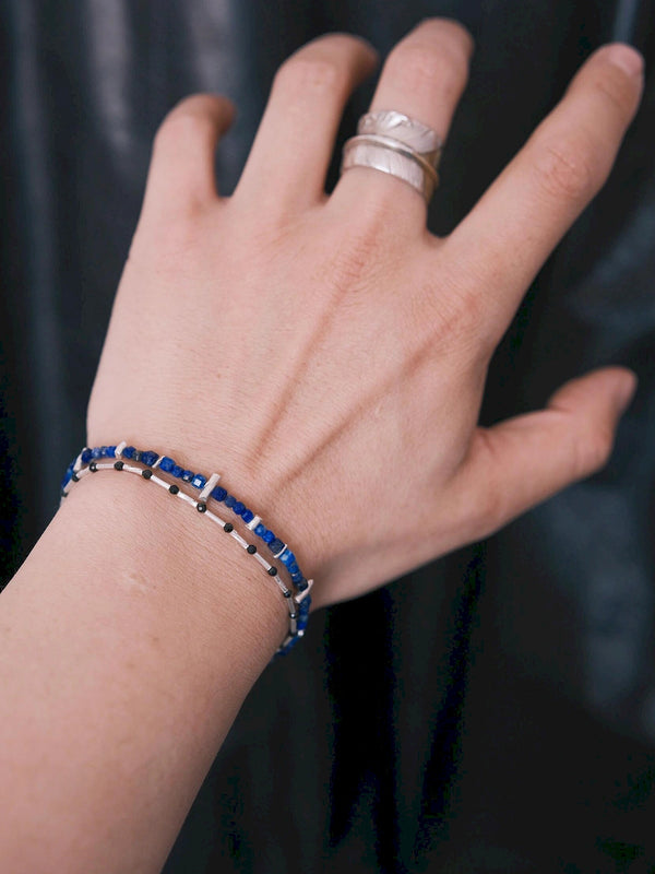 Men’s lapis lazuli bracelet worn on wrist with silver ring, daily wear styling, blue identity jewelry for a clean masculine look.
