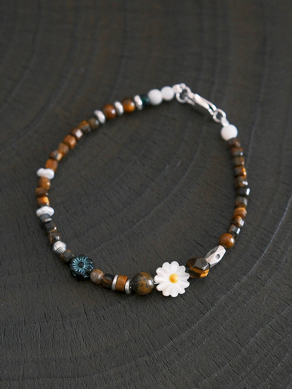 Minimal workday jewelry styling with unisex tiger eye bracelet, silver details and mother-of-pearl daisy for quiet daily confidence.