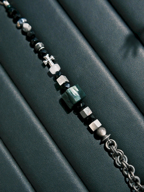 Dark Monolith men’s bracelet photographed on black leather with seraphinite, obsidian, silver cubes, and cold masculine texture.