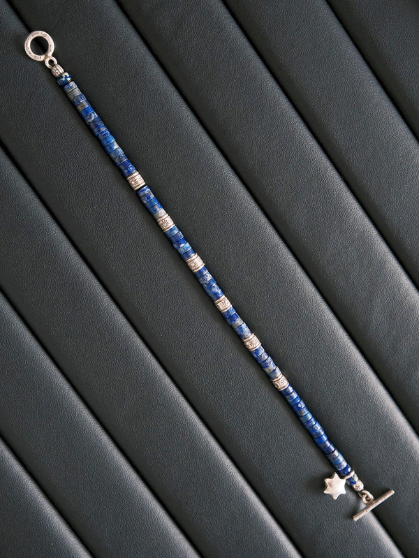 Close-up detail of lapis lazuli beads, Miyuki colored-glaze accents, 990 fine silver charm, and textured silver spacer details.