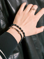 Urban Stoic black onyx bracelet worn with black leather jacket, polished hematite accents, cold masculine styling.