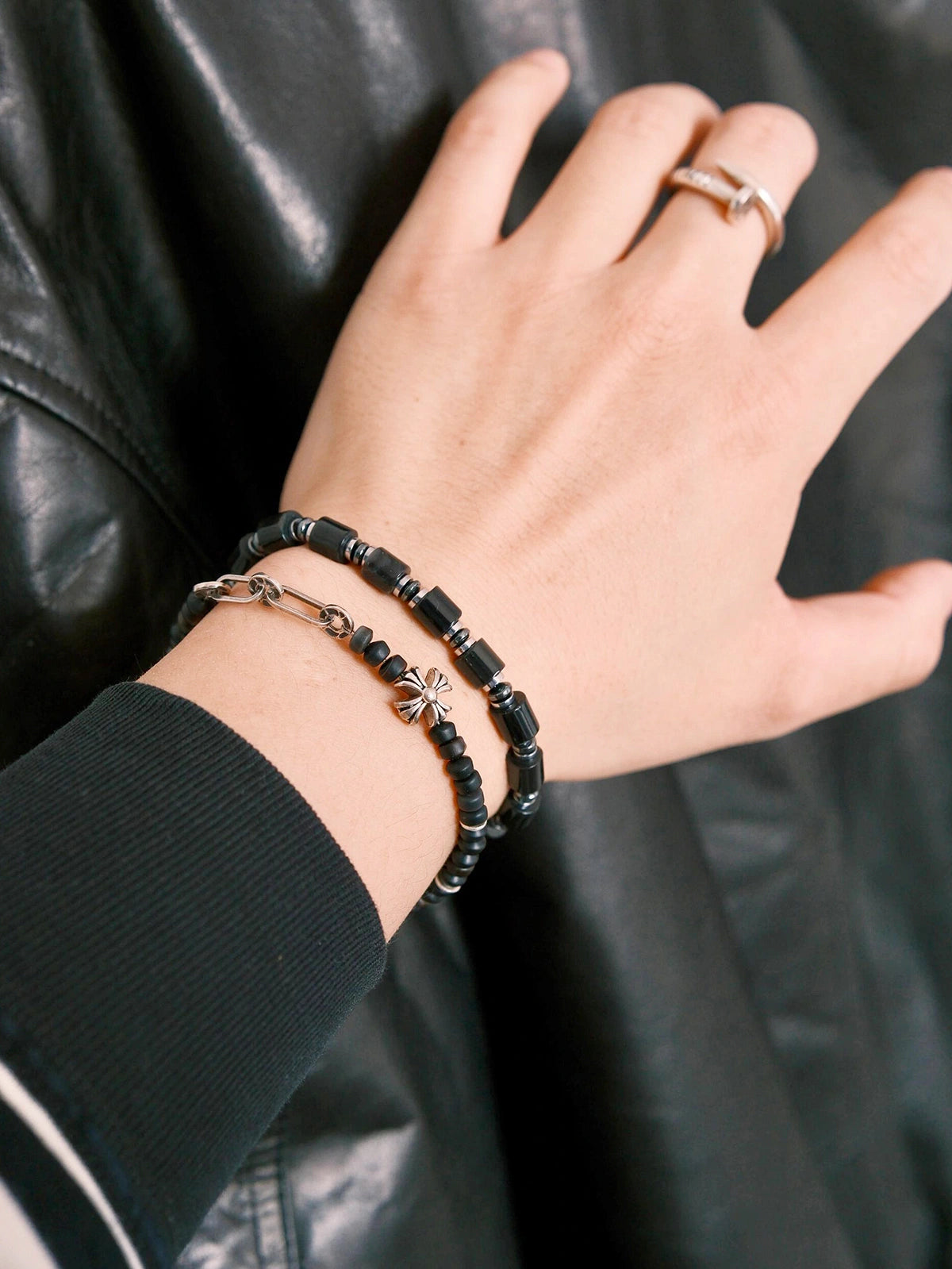 Urban Stoic black onyx bracelet worn with black leather jacket, polished hematite accents, cold masculine styling.