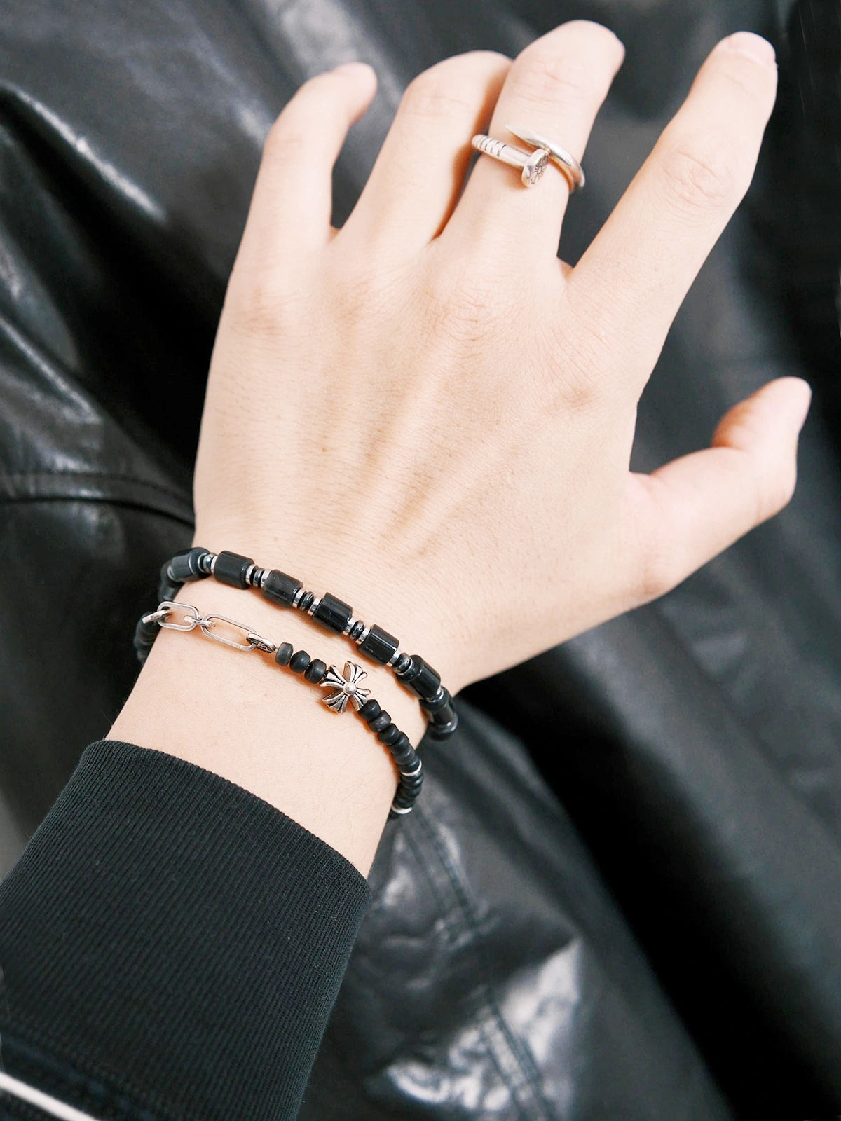 Urban Stoic black onyx bracelet worn with black leather jacket, polished hematite accents, cold masculine styling.