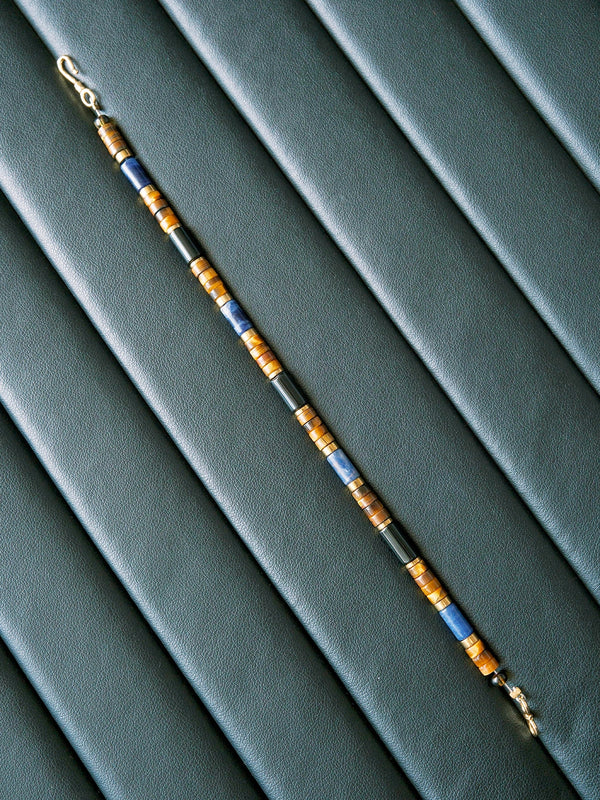 Men’s Urban Stoic bracelet on black desk setting, tiger eye and K2 blue stone, business casual jewelry for daily focus.