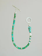 Flat lay of men’s turquoise, aventurine and pearl bracelet with hammered silver toggle clasp, natural mineral style
