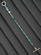 Moody men’s bracelet detail with turquoise and silver contrast, grounded masculine jewelry aesthetic