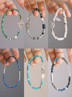 Hand holding Mineral Soul Series Mountain Tide bracelet, turquoise beads, baroque pearl and silver details in close-up view