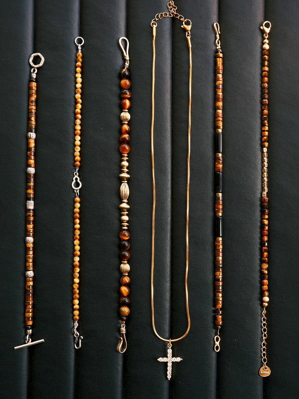 Men’s tiger eye bracelet on black leather background, refined brass and natural stone details with bold Urban Stoic energy.