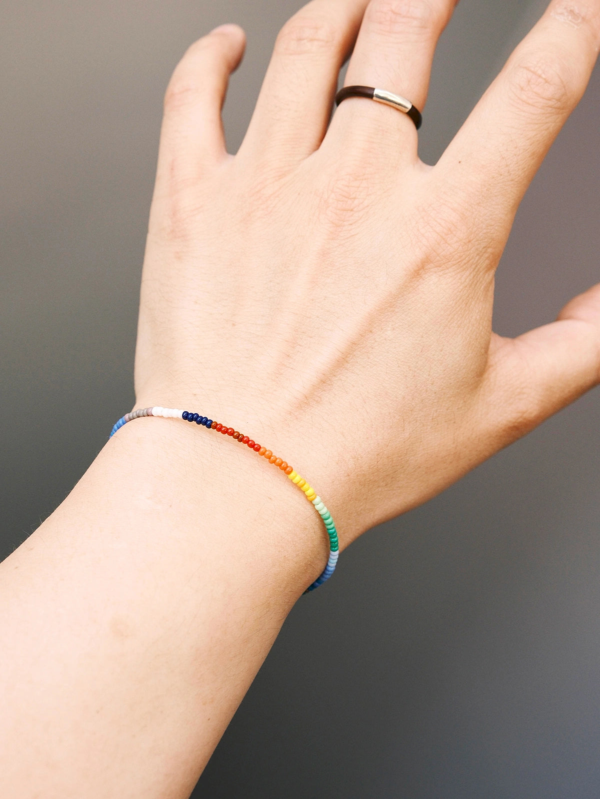 Men’s thin colored-glaze bracelet worn on wrist, rainbow bead detail with sterling silver, casual daily wear style