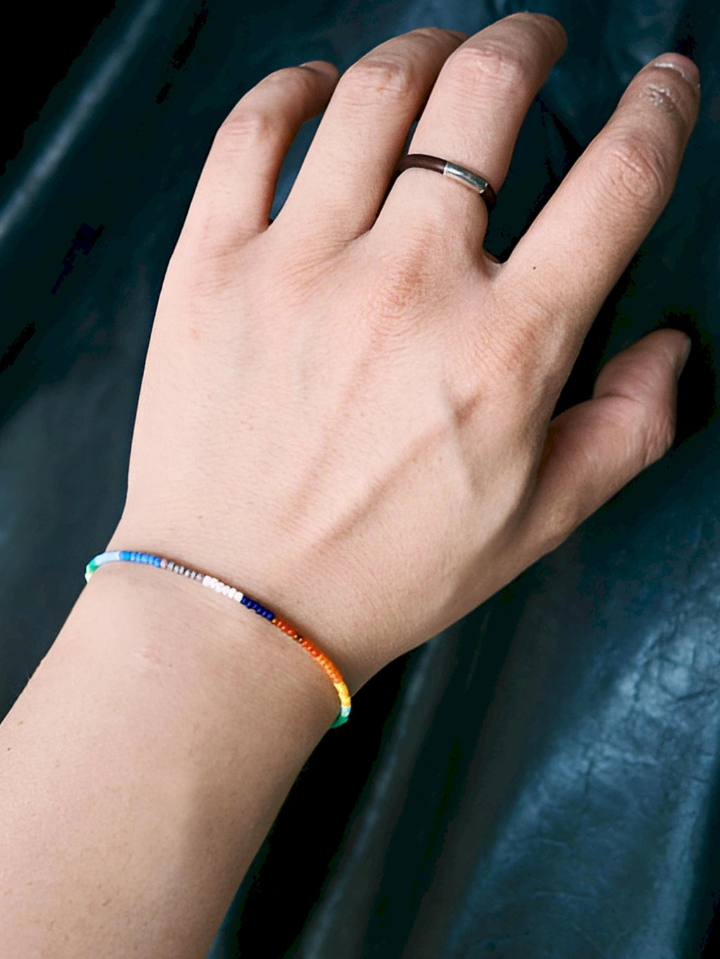 Close-up wrist shot of Identity Series Neon Thread bracelet, ultra-thin colored-glaze beads and sterling silver detail
