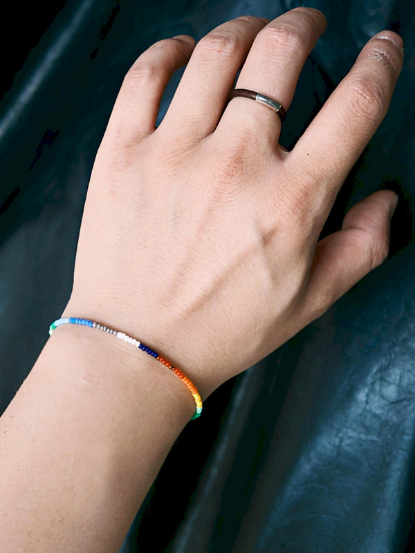 Close-up wrist shot of Identity Series Neon Thread bracelet, ultra-thin colored-glaze beads and sterling silver detail
