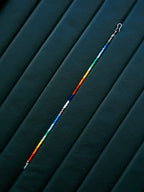 Straight layout of thin rainbow colored-glaze bracelet, sterling silver clasp, modern men’s beaded bracelet design