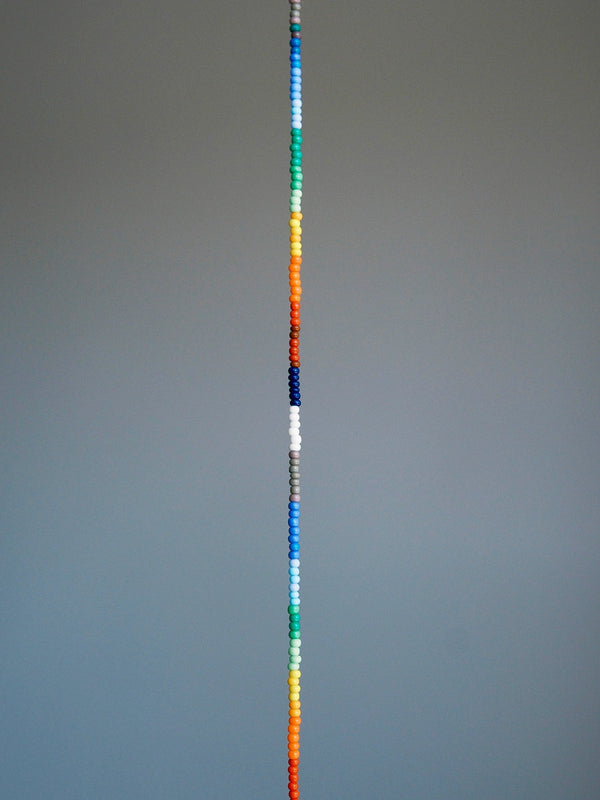 Straight layout of thin rainbow colored-glaze bracelet, sterling silver clasp, modern men’s beaded bracelet design