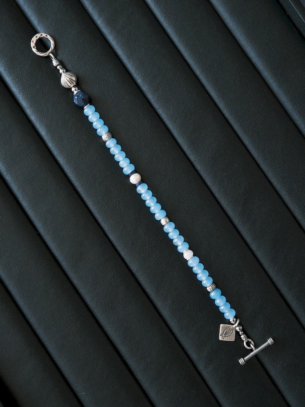 Men’s blue chalcedony bracelet beside notebook and silver pen, Mineral Soul Series, minimal work desk jewelry aesthetic