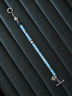 Men’s blue chalcedony bracelet beside notebook and silver pen, Mineral Soul Series, minimal work desk jewelry aesthetic