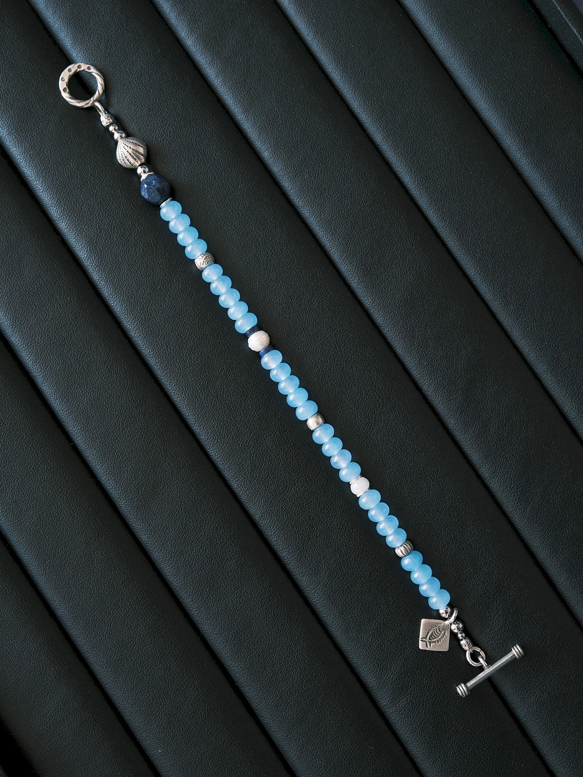 Men’s blue chalcedony bracelet beside notebook and silver pen, Mineral Soul Series, minimal work desk jewelry aesthetic