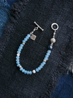 Close-up of blue chalcedony beads, natural pearl, lapis lazuli, jade accent and sterling silver details on Blue Shoal bracelet