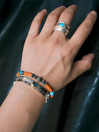Close-up wrist shot of men’s turquoise bracelet with sunset orange beads, sterling silver clasp, and refined brass accents for grounded confidence.