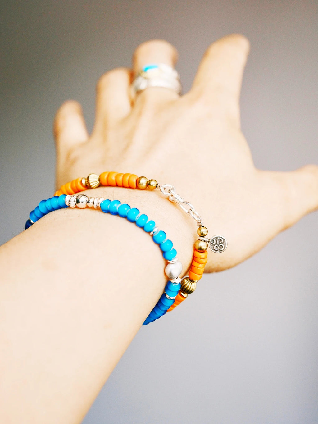 Weekend casual men’s bracelet styling with turquoise, sunset orange colored-glaze, denim-friendly vintage western aesthetic.