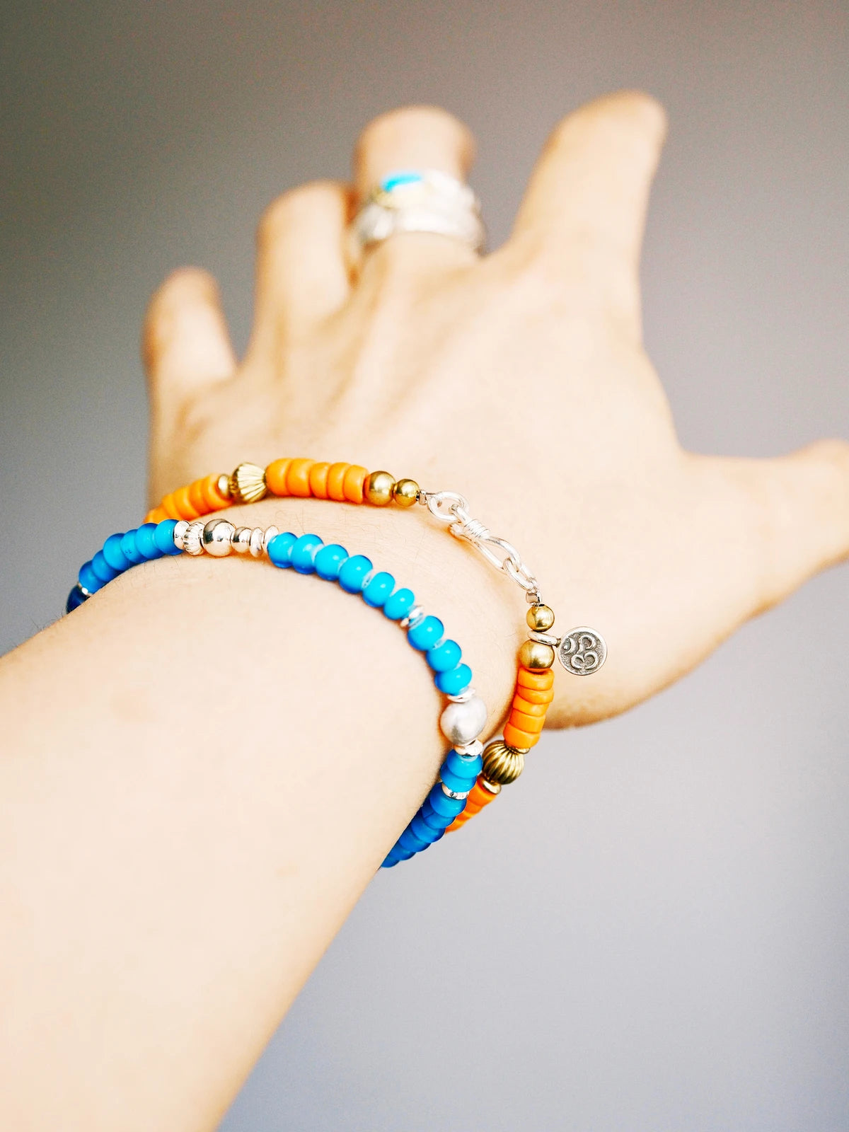 Weekend casual men’s bracelet styling with turquoise, sunset orange colored-glaze, denim-friendly vintage western aesthetic.