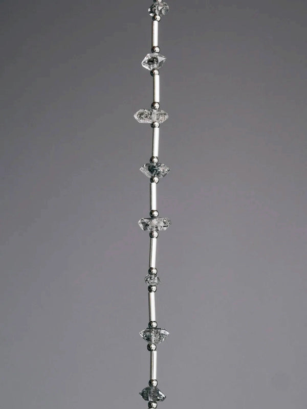 Close-up of raw Herkimer-style flash quartz, sterling silver tubes, and skin-friendly titanium steel spacer beads