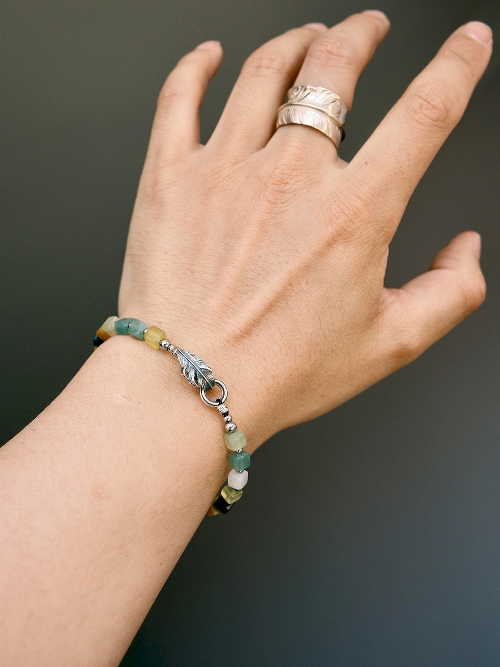 Men’s Xiuyu jade bracelet styled with formal work outfit, silver feather detail, refined masculine accessory