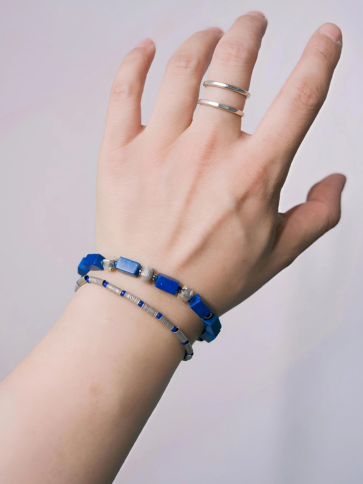 Lapis lazuli and 990 fine silver bracelet worn on the wrist, showing its angular blue beads and refined everyday proportions.