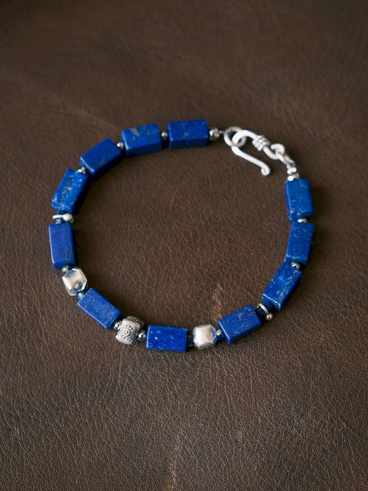 Full view of the Blue Vanguard bracelet with rectangular lapis lazuli beads, fine silver accents and a silver hook closure.